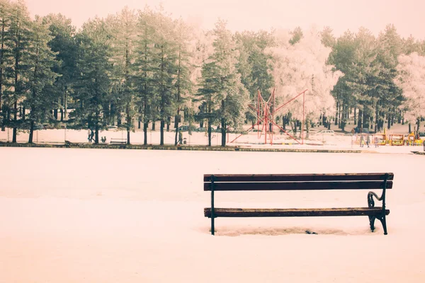 Одинокая скамейка в зимнее время — стоковое фото