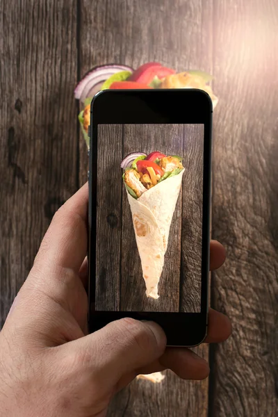 depositphotos 74067997 stock photo man photographing wrap sandwich with курица с телефоном картинки