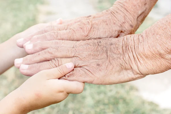 Young hands holding senior hands — Stock Photo, Image