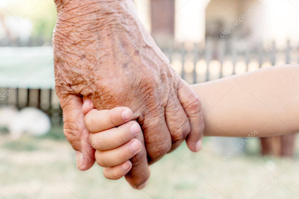 child holding grandparent for hand