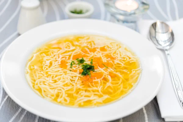 Plate of chicken soup with carrots and noodles on white plate — Stock Photo, Image