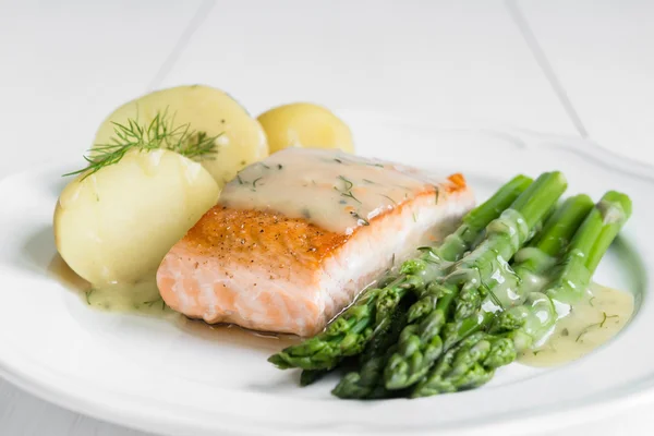 Gegrilde zalm met gekookte aardappelen en asperges op witte plaat — Stockfoto