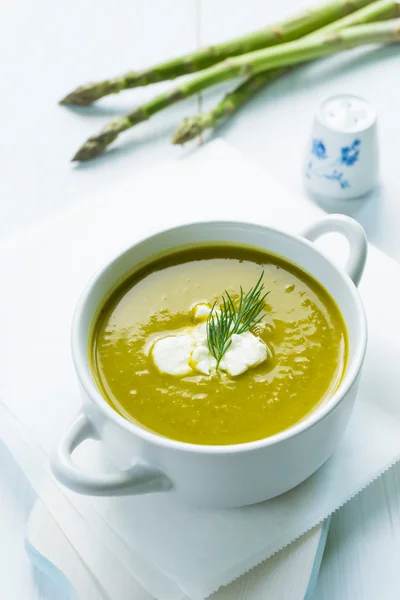 Bowl of asparagus soup topped with fresh cream and dill — Stock Photo, Image