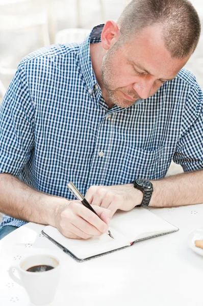 Homem escrevendo no caderno — Fotografia de Stock