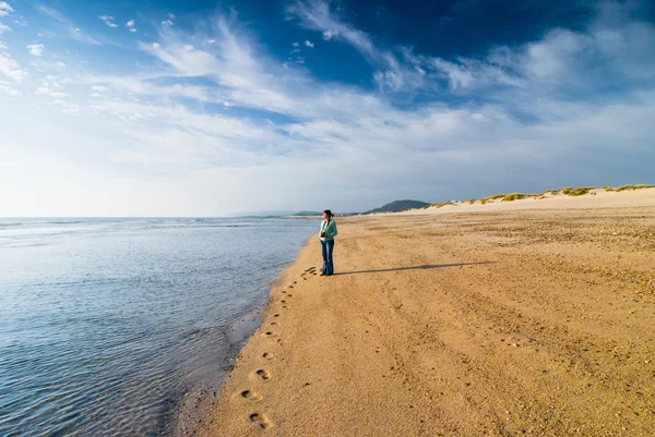 Mulher com câmera em pé na praia — Fotografia de Stock