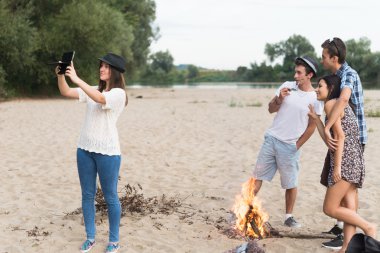 Genç yetişkinler Sandy Beach üzerinde fotoğraf ve Selfies çekimi