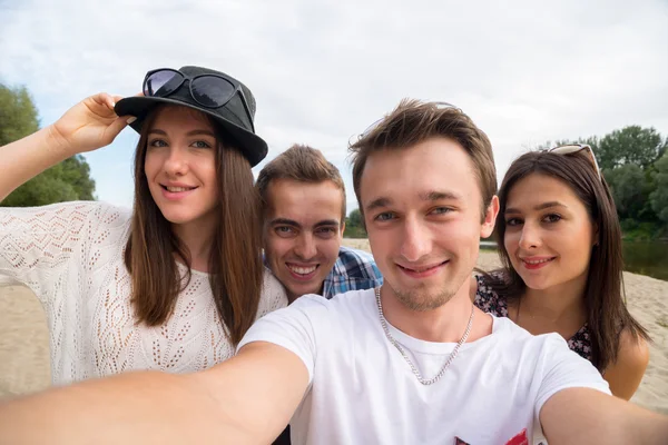 Młodzi przyjaciele uśmiechający się przy Selfie na piaszczystej plaży — Zdjęcie stockowe