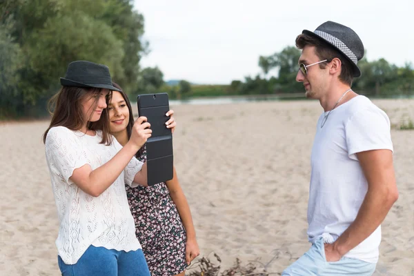 Adultos jóvenes tomando fotos y selfies en Sandy Beach — Foto de Stock