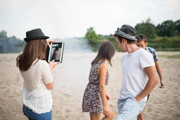 Adultos jóvenes tomando fotos y selfies en Sandy Beach — Foto de Stock