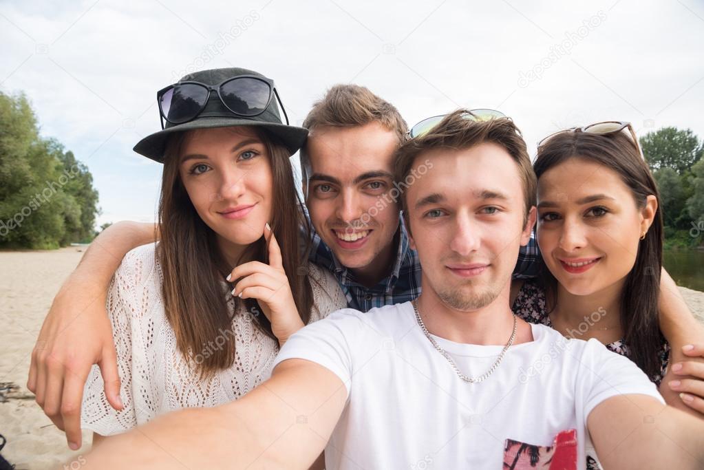 Young Smiling Friends Taking Selfie On Sandy Beach