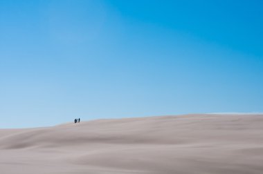 Üç kişi kabuklarıyla Sandy mavi arka plan gökyüzü