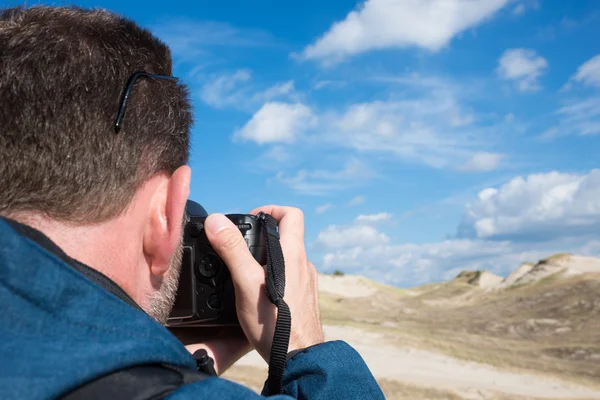 Widok z tyłu mężczyzna photographying krajobrazu z cyfrowy aparat fotograficzny — Zdjęcie stockowe