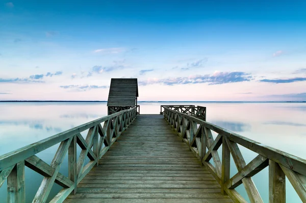 Dřevěné molo na klidné jezero při západu slunce — Stock fotografie