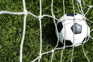 Yeşil arkaplan ile gol ağındaki futbol topu