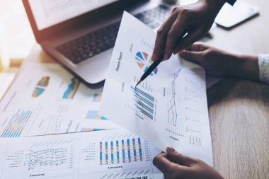 Toplantı odasında iş belgesine işaret eden pazarlama müdürünün eli, ahşap masadaki defter - iş konsepti