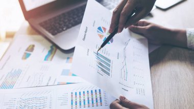 Toplantı odasında iş belgesine işaret eden pazarlama müdürünün eli, ahşap masadaki defter - iş konsepti