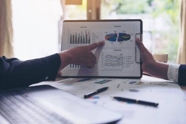 İş dünyasından insanların finansal görüntüsü. İş belgesi sunum özeti raporu. Toplantıda tartışılırken, ahşap masadaki not defteri.