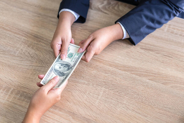 close up hand of business giving or paying money  US dollar bill