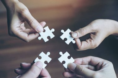 Grup iş ortaklarının eli kapanıyor. İnsanlar yapboz, iş ekibi stratejisi kavramını bir araya getiriyorlar.