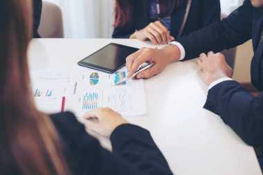 Toplantı odasında iş belgesine işaret eden pazarlama müdürünün eli, ahşap masadaki defter - iş konsepti