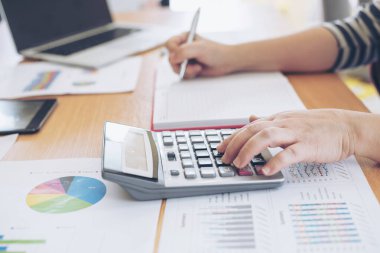 Yıllık gelir vergisi ve şirket gelir hesaplamasını hesaplayan hesap makinesiyle çalışan muhasebecinin elini kapat - iş konsepti