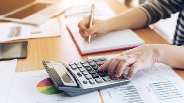 Yıllık gelir vergisi ve şirket gelir hesaplamasını hesaplayan hesap makinesiyle çalışan muhasebecinin elini kapat - iş konsepti