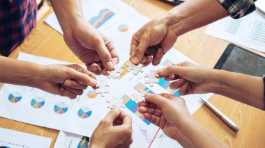 Grup iş ortaklarının eli kapanıyor. İnsanlar yapboz, iş ekibi stratejisi kavramını bir araya getiriyorlar.