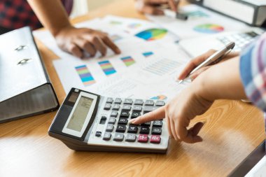 Yıllık gelir vergisi ve şirket gelir hesaplamasını hesaplayan hesap makinesiyle çalışan muhasebecinin elini kapat - iş konsepti