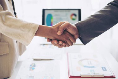 İş ortaklığı el sıkışması, insanların tokalaşması ofis masası üzerindeki birliği gösteren toplantıyı bitirmesi, takım çalışması konsepti.