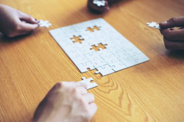 Grup iş ortaklarının eli kapanıyor. İnsanlar yapboz, iş ekibi stratejisi kavramını bir araya getiriyorlar.