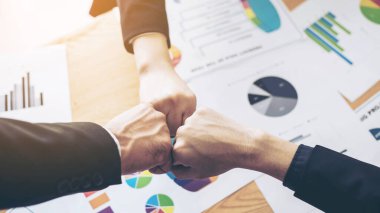 İş ortaklığı elini kapatıyoruz. İnsanlar toplantının sonunda ofis masasında birlik ve iş ortağı takım çalışması kavramını gösteriyorlar.