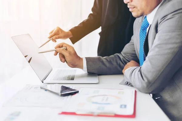 close up hand of marketing manager employee pointing at business document on laptop computer during discussion at meeting room  - Business concept