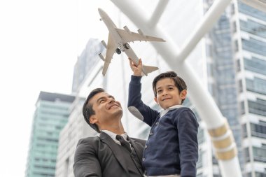 Baba, havacının oyuncak uçağını canlandıran oğlunu taşıyor. Hayal gücü, iş bölgesindeki şehirde pilot olmanın hayalini kuruyor. Baba ve oğul mutlu aile kavramı.