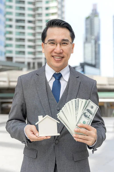 Retrato Asiático Hombre Negocios Con Billetes Dólar Casa Modelo Distrito —  Fotos de Stock