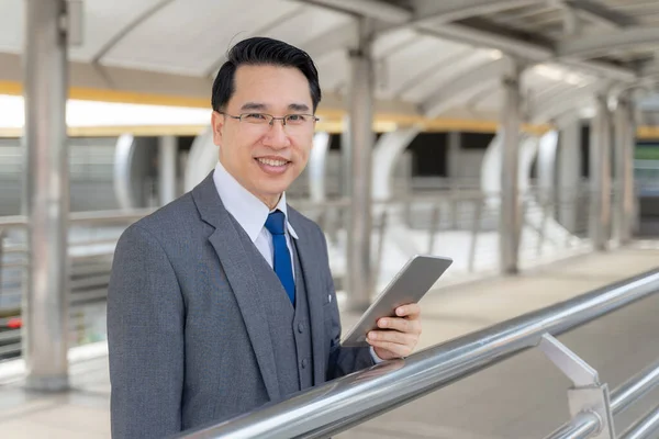 Portrait asian business man business district ,senior visionary executives leader with business vision , smart phone in hand - lifestyle business people concept
