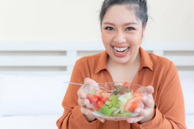 Kilolu Asyalı tombul kadın, şişman kadın, şişman kız, tombul, sebze salatası yiyen - yaşam tarzı kadın diyet zayıflama aşırı kilo verme sorunu kavramı