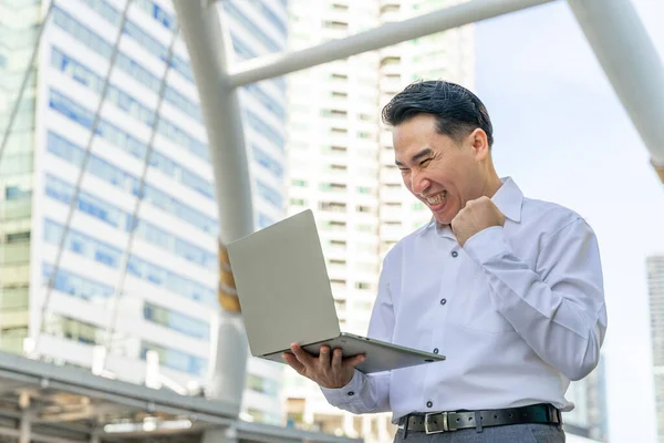 Business asian man using laptop computer on business district urban - lifestyle business people concept