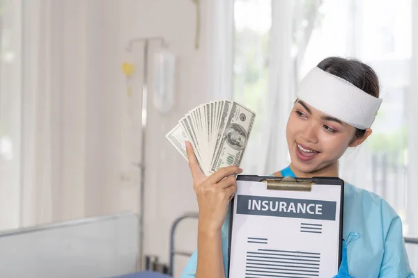 病院のベッドの上の事故患者の傷害の女性は私達を保持しているドル札は保険金を得ることから幸せ感じる保険会社から 医療概念 — ストック写真