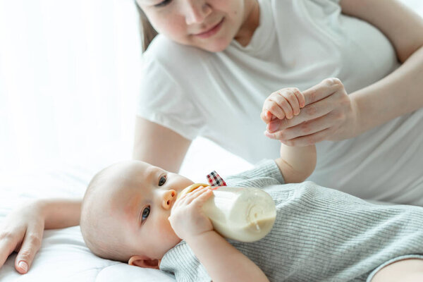 Babies who drink milk from a bottle with a mother next to them.