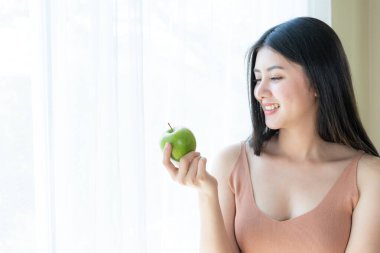 Beautiful beauty sexy woman slim holding green apple on white bedroom background
