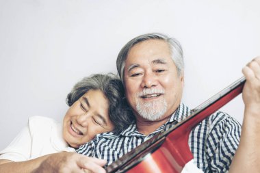 Mutlu yaşlı çift gülümsüyor, yaşlı çift yaşlı adam ve yaşlı kadın dinleniyor yatak odasında akustik gitar çalıyorlar - son sınıf yaşam tarzı konsepti 