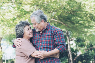 Mutlu aşk yaşlı çift gülen surat, yaşlı çift yaşlı adam ve yaşlı kadın ormanda dinleniyor. 