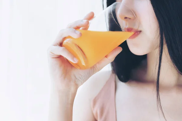 アップの美しさの女性アジアのかわいい女の子は幸せな朝の健康のためにオレンジジュースを飲む感じ 彼女の家の白い寝室の背景で時間を楽しんで ライフスタイルの美しさの女性のコンセプト — ストック写真