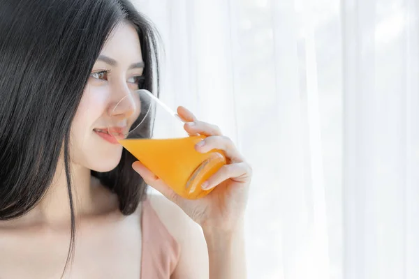 美しい美しさの女性アジアのかわいい女の子は幸せな朝の健康のためにオレンジジュースを飲む感じ 彼女の家の白い寝室の背景で時間を楽しんで ライフスタイルの美しさの女性のコンセプト — ストック写真
