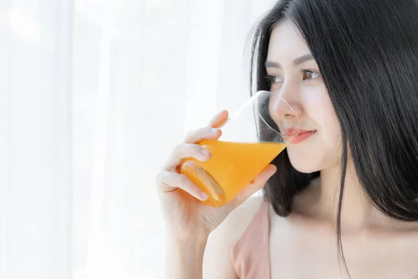 美しい美しさの女性アジアのかわいい女の子は幸せな朝の健康のためにオレンジジュースを飲む感じ 彼女の家の白い寝室の背景で時間を楽しんで ライフスタイルの美しさの女性のコンセプト — ストック写真