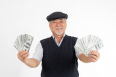 Business senior bohatý muž držící peníze americké dolarové bankovky v ruce na bílém pozadí, koncept pro senior úspěch podnikání