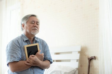 Yaşlı adam ağlıyor, ölmüş karısının görüntüsüne sarılıyor, sevgilisini hatırlıyor musun - ne yazık ki kıdemli konsept