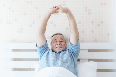 Son sınıf öğrencisi mutlu. Sağlıklı bir sabah uyanıp, yatak odasının arka planında eğleniyor. Son sınıf mutluluk kavramı.