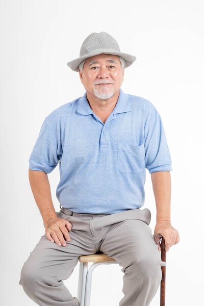 Portrait Asian senior man , old man , feel happy good health wearing a hat and holding a walking stick isolated on white background - lifestyle senior male concept