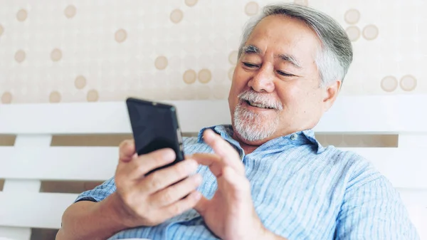 Hombre Mayor Usando Teléfono Inteligente Sonriendo Sentirse Feliz Cama Casa —  Fotos de Stock